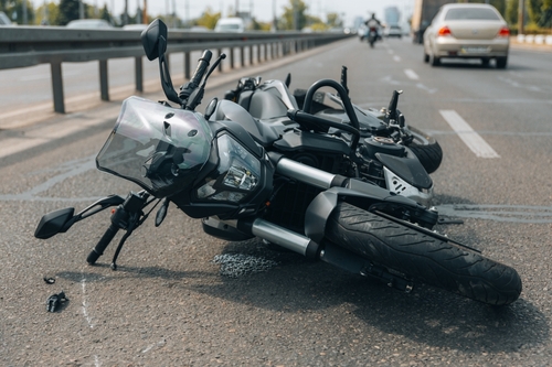 Fort Mill motorcycle accident lawyer inspecting a motorcycle laying down in the road after a crash