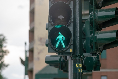 Green crosswalk signal indicating it is safe to walk, used by a pedestrian accident lawyer to illustrate right-of-way issues.