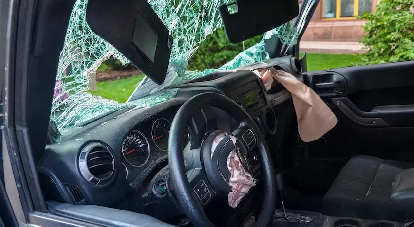 The vehicle interior is showing a deployed airbag and shattered windshield damage from a local car accident requiring legal representation in Spartanburg SC.