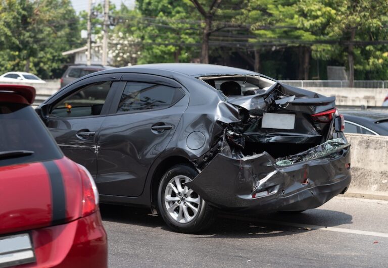 A severely damaged black vehicle is on the highway and requires immediate car accident claim filing with the insurance company in Spartanburg SC.