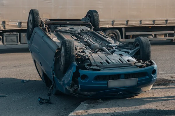 Overturned car after a crash demonstrating how comparative negligence affects fault determination.