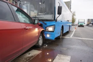 Bus crashing into a car on a city street representing cases handled by a Fort Mill bus accident lawyer.